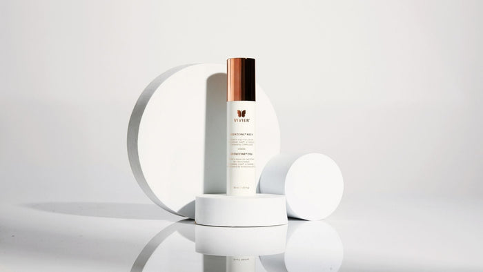 Vivier GrenzCine Neck cream in white packaging with a rose gold cap displayed on modern white pedestals.