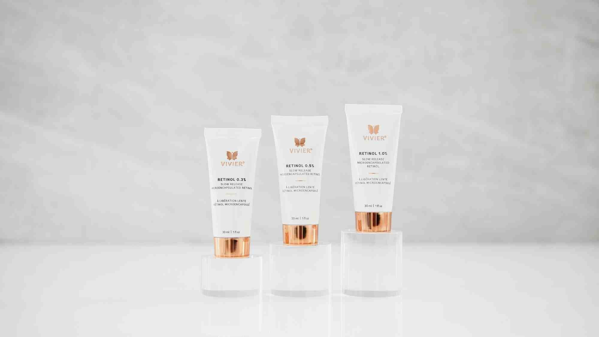Collection of Vivier skincare serums in amber glass bottles with rose gold droppers displayed side by side.