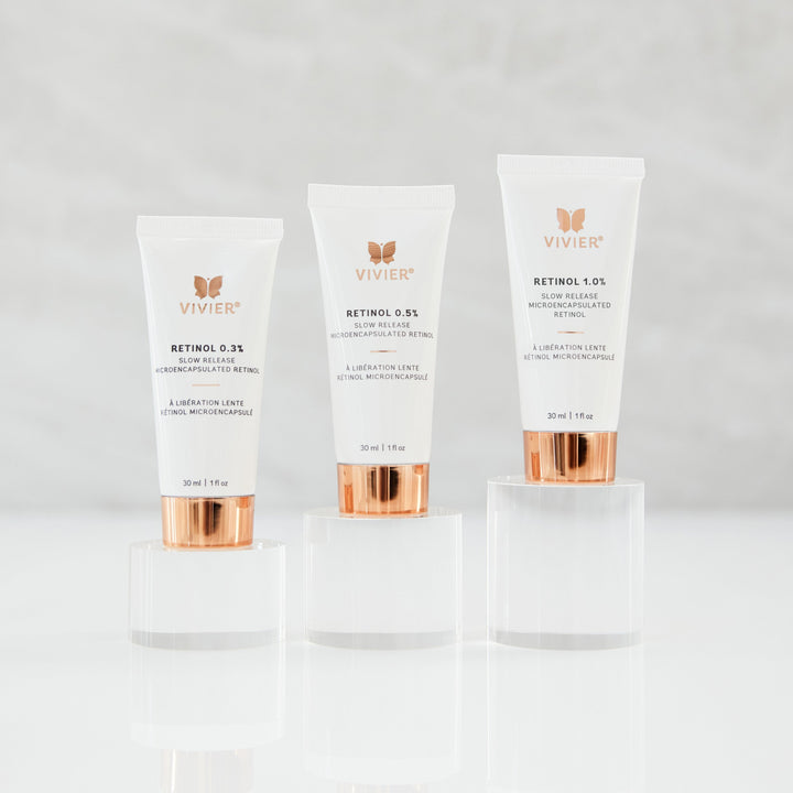 Three Vivier Retinol products (Retinol 0.3%, 0.5%, and 1.0%) standing on clear acrylic platforms against a soft neutral background.